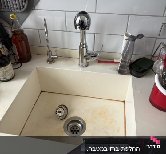 כיור מטבח עם ברזים וכלים שונים